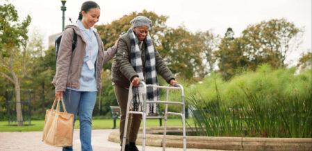 Nurse, support and walker with old woman in park for helping, person with a disability and retirement. Elderly care, nursing and rehabilitation with caregiver and patient in nature for healthcare