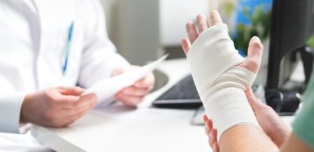 man with injured hand talking to a doctor
