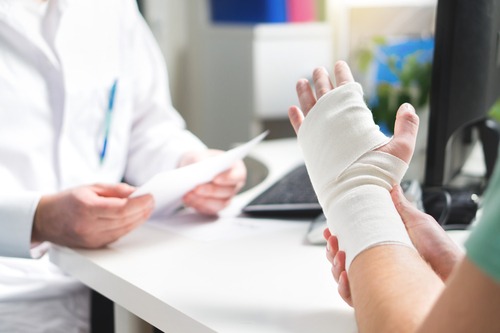 man with injured hand talking to a doctor