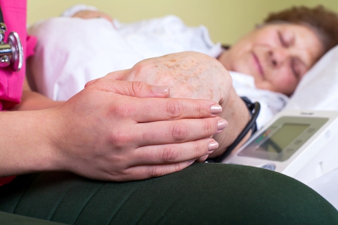 elder woman laying on the bed suffering from an illness