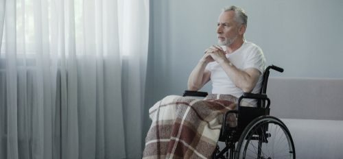an old man sitting inside his room alone in a nursing home
