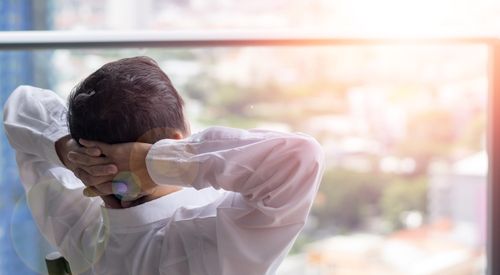 employee looking out the window of his office