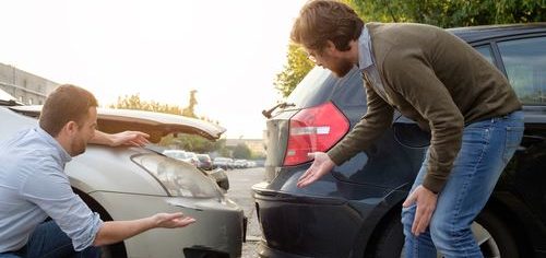 two men observing car accident