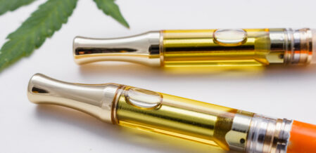 vape pens with a marijuana leaf in the background