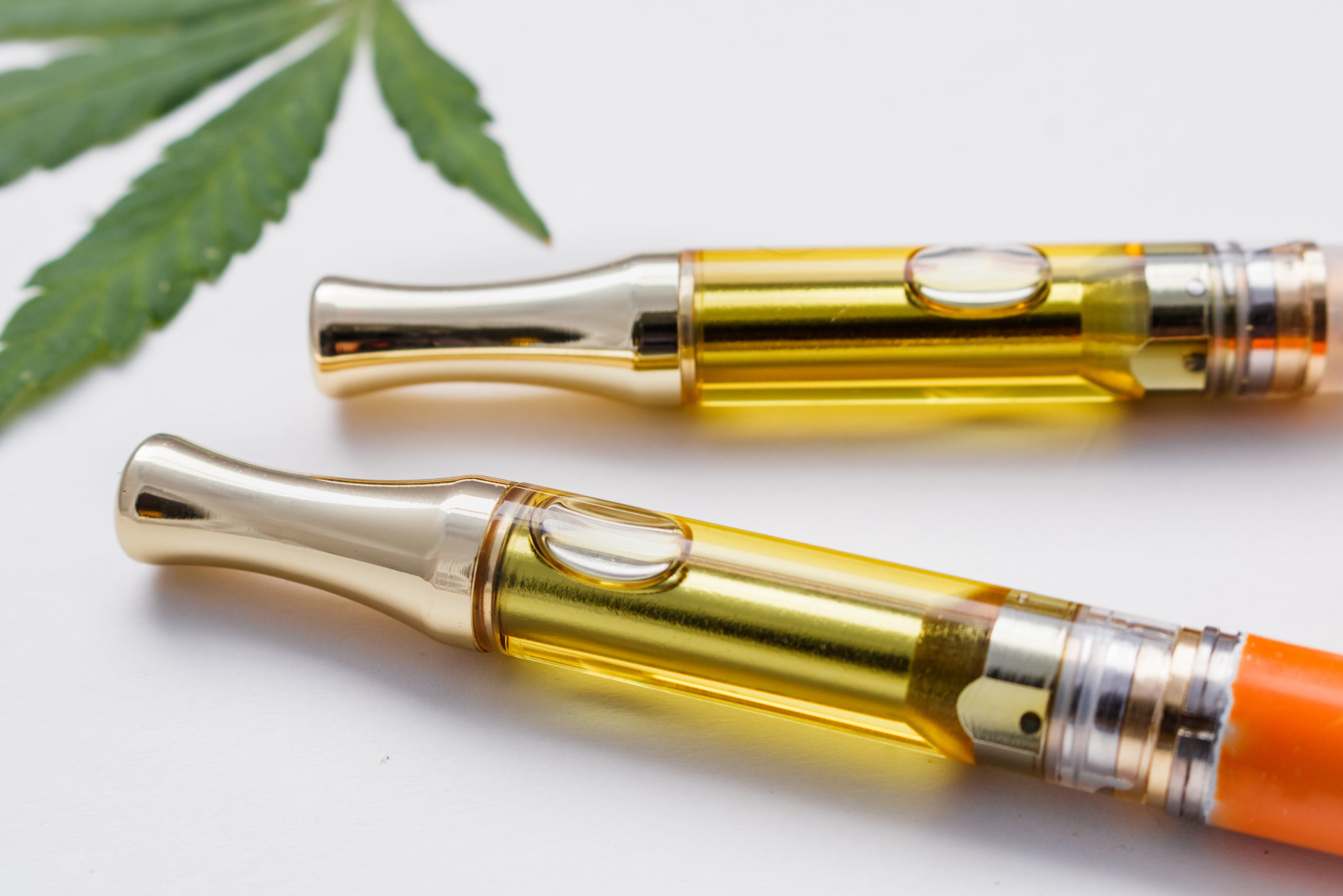 vape pens with a marijuana leaf in the background