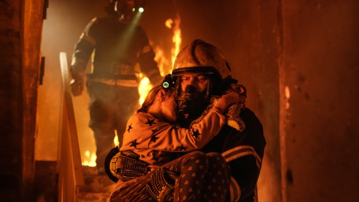 firefighter carrying young girl from burning building in South Carolina