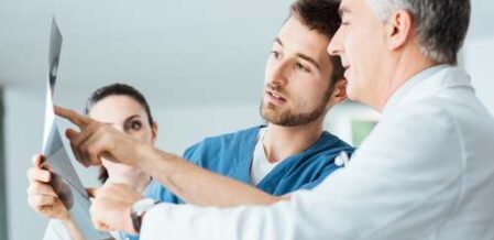 Doctor and workers comp case manager reviewing xrays