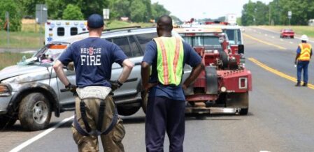 first responders watching a car get towed away