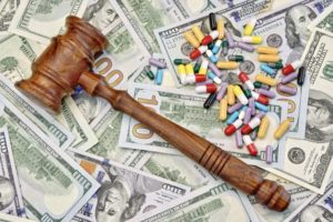 Gavel and pills spread out over dollar bills to signify the expense in drug injury lawsuits.