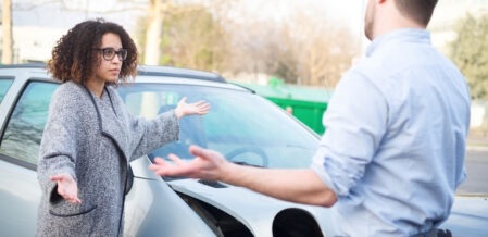 Man and woman arguing over who is at fault after a car accident
