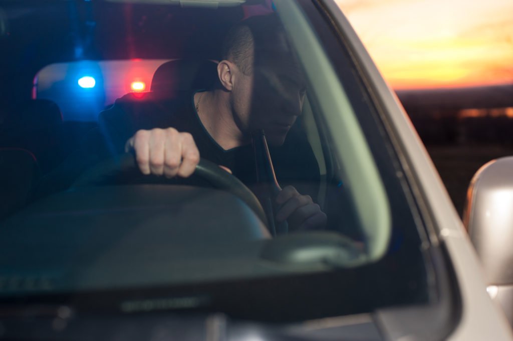 Man with beer bottle being pulled over