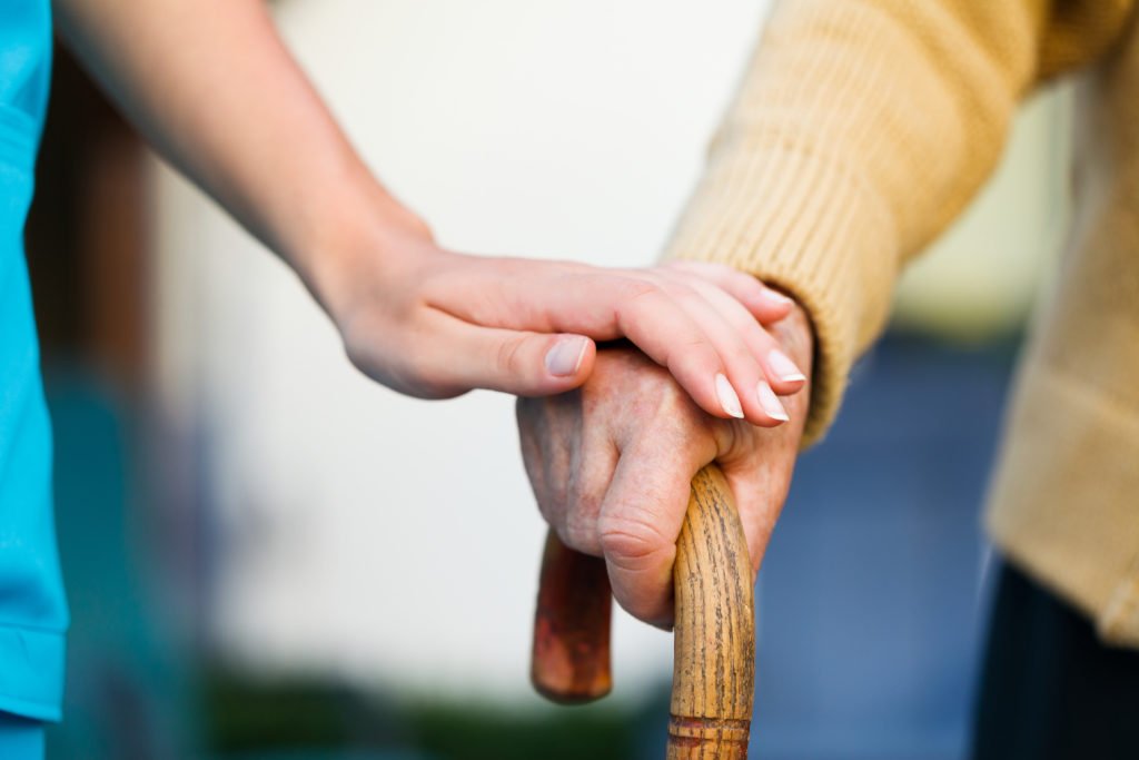 Concerned daughter holds mothers hand concerned to symbolize nursing home abuse or neglect
