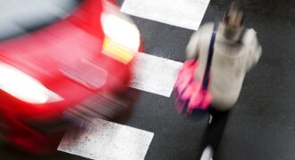Woman crossing the road about to be hit by a car