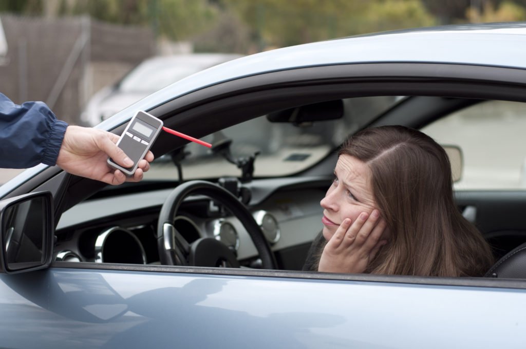 female being asked to blow in breathalyzer