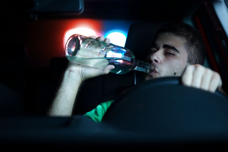 young man drinking while driving
