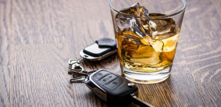 a glass of whiskey next to car keys