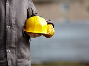 a construction worker holding a yellow hard hat
