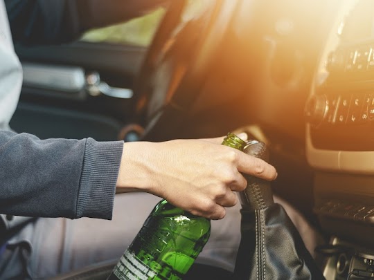 drunk driver in summerville holding an alcohol bottle while driving