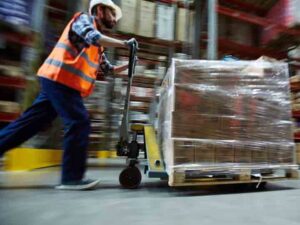 warehouse worker pushing a heavy trolley