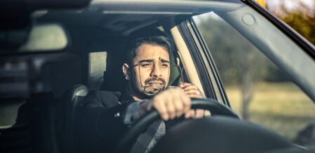 a man struggling to see while driving