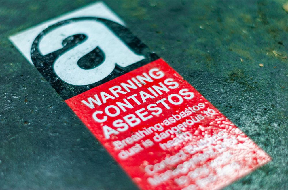 Image of a warning sign labeled "contains asbestos"