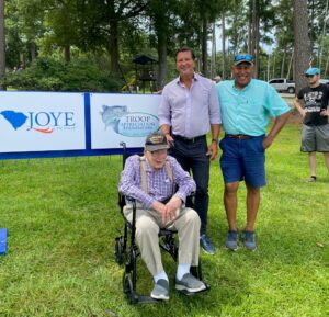 Attorney Ken Harrell of Joye Law Firm stands with WWII Veteran Jack Holladay and Michael Glover, The Troop Appreciation Foundation’s President. 