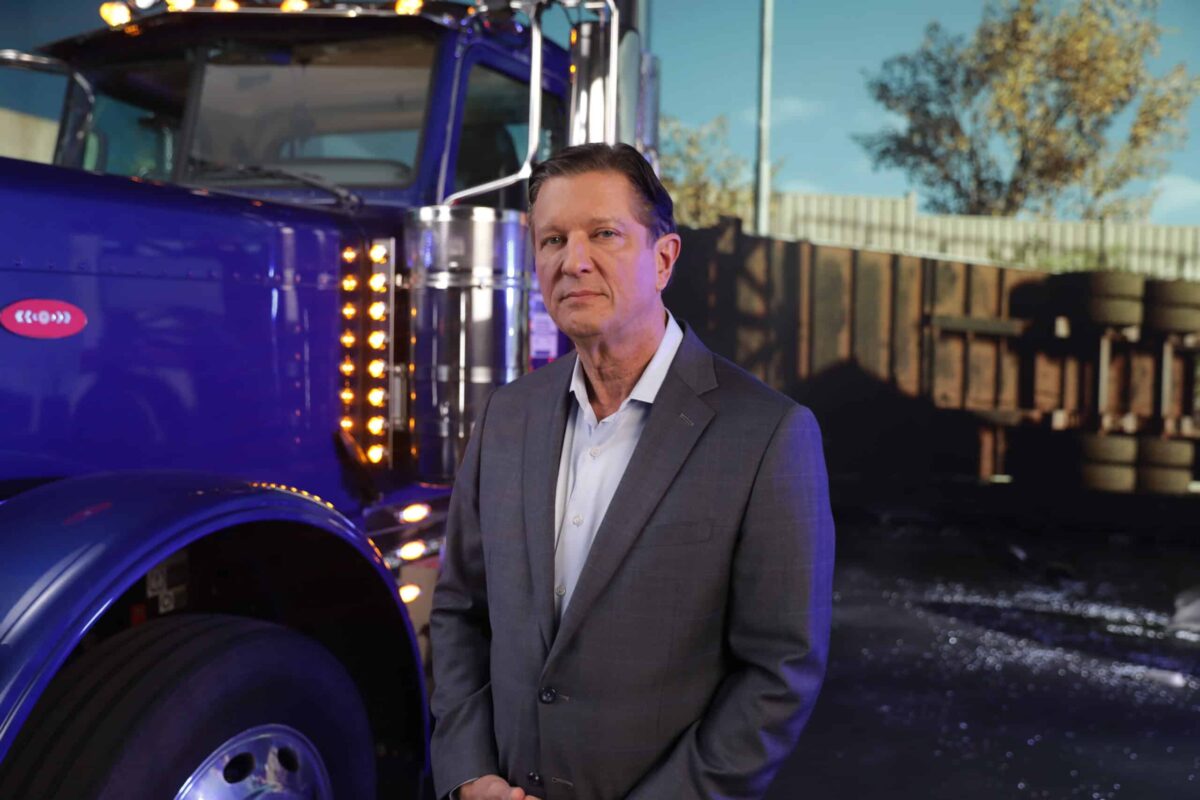 Ken Harrel standing in front of an 18-wheeler