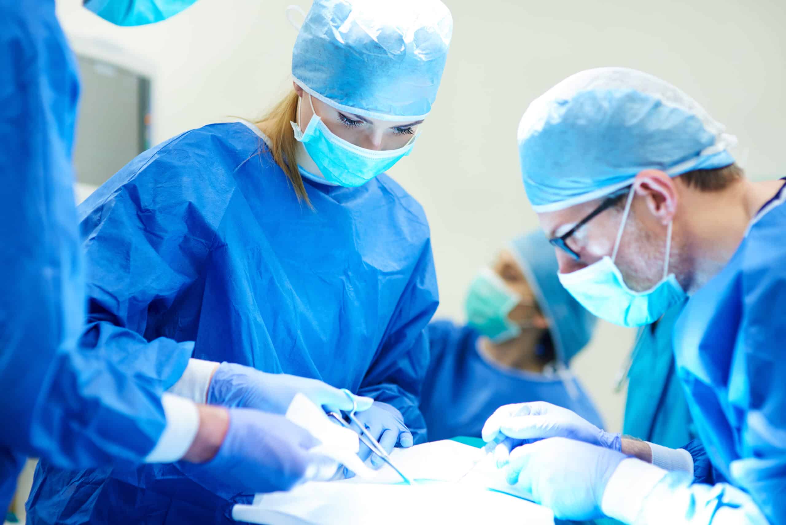 Female doctor using medical scissors over surgery