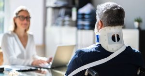 Man with a neck brace on talking to his doctor
