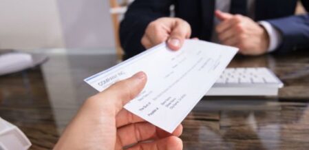 an attorney handing over a settlement check