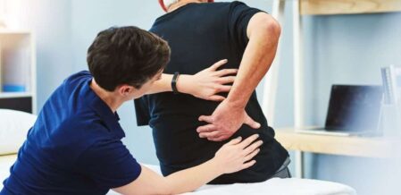 Image of a doctor examining a patient complaining of back pain
