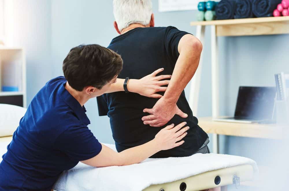 Image of a doctor examining a patient complaining of back pain