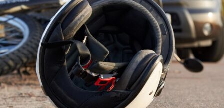 Image of a motorcycle helmet lying on the ground near a crashed bike