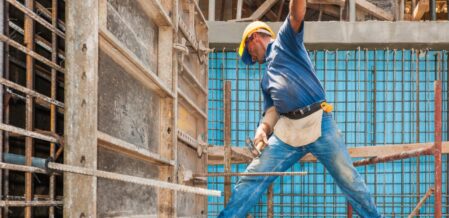 Image of a construction worker balanced in a precarious position