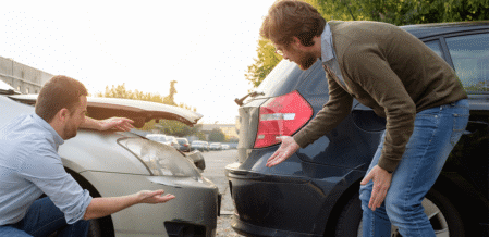 two men arguing about the damages to their car after a crash