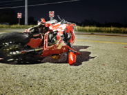 a motorcycle on its side in the middle of a street after an accident