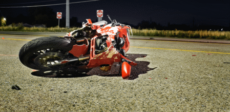 a motorcycle on its side in the middle of a street after an accident