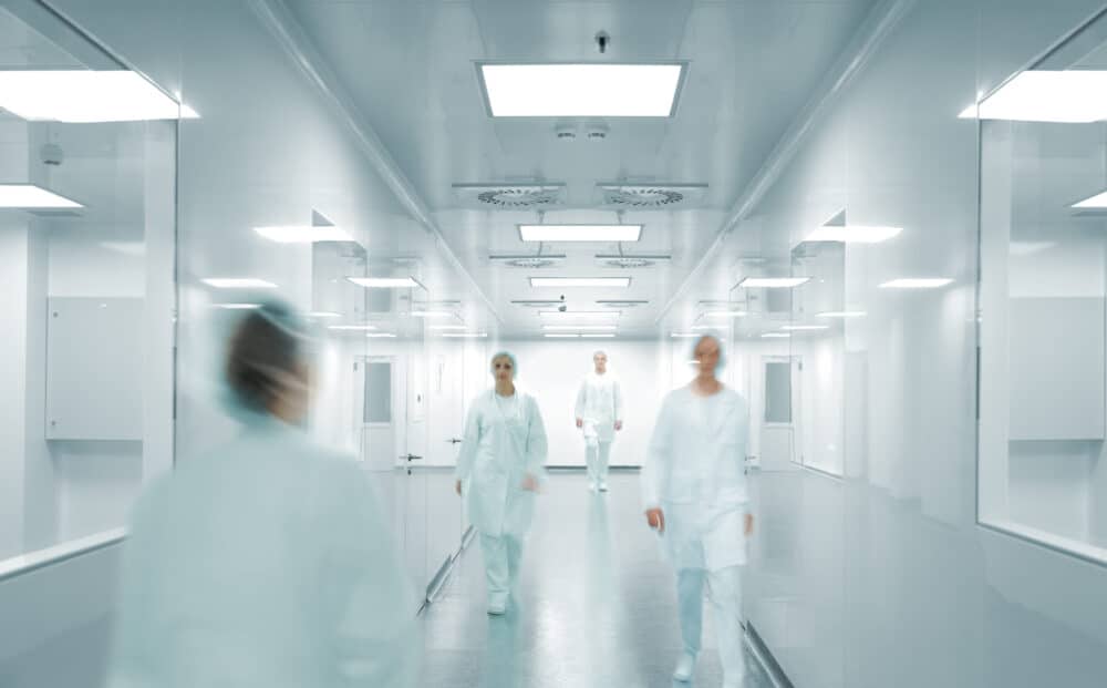 Doctors walking down the hall of a hospital while treating a patient with kidney disease caused by PPIs.