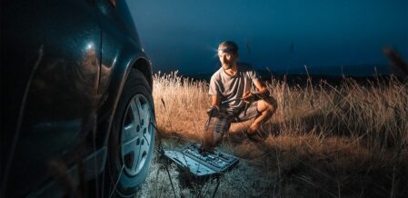 man trying to change the tire of his car at night