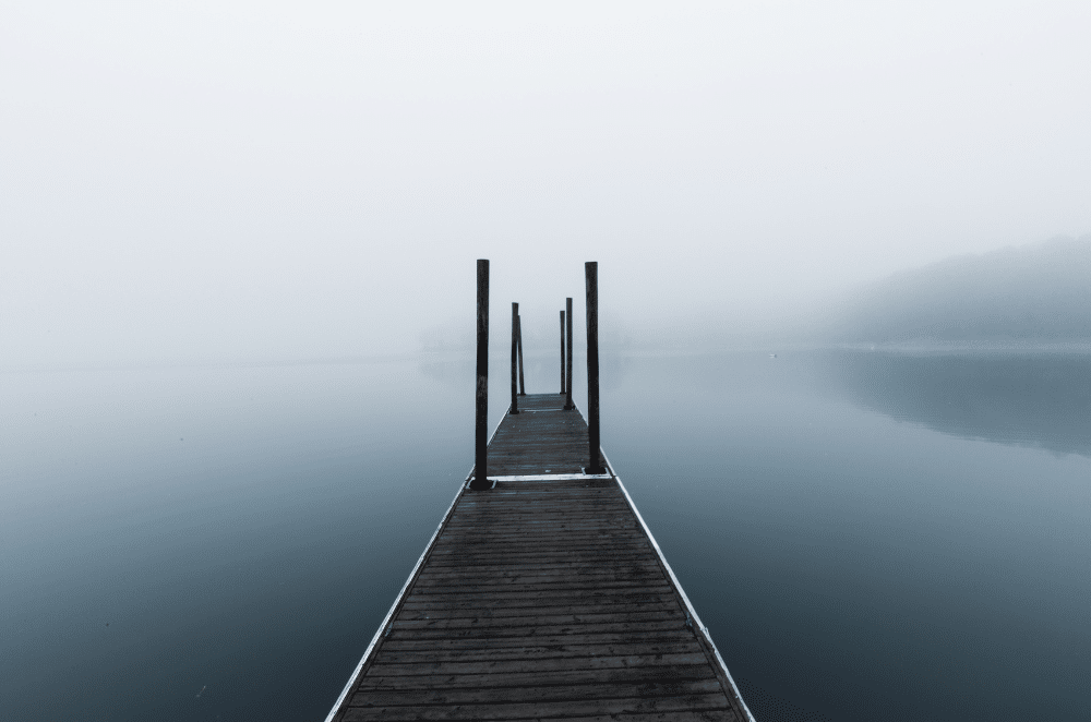 Image of a dock on a lake covered in fog