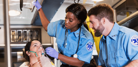 Image of two parademics tending to a woman in an ambulance
