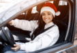 Image of a woman in a santa hat in the driver's seat of a car