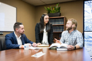 Three of Joye Law Firms attorneys at a table discussing a case