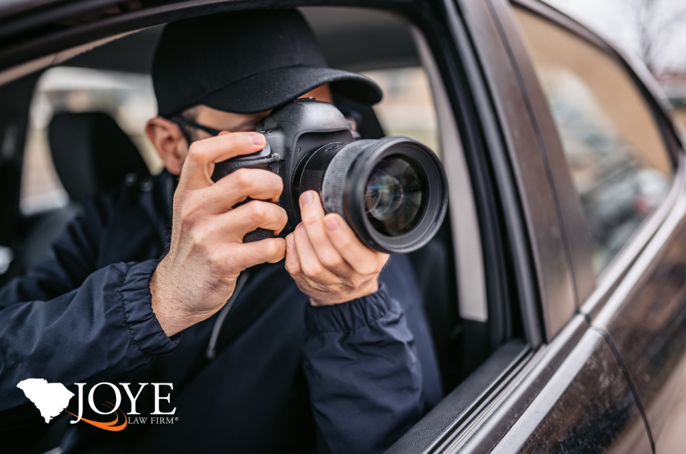 Image of someone taking photos out the window of their car with a camera with a zoom lens