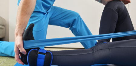 Midsection Of Physical Therapist Assisting Patient In Exercising