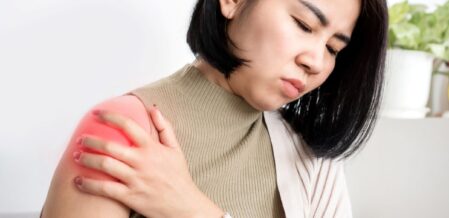 Woman holding her upper arm in discomfort